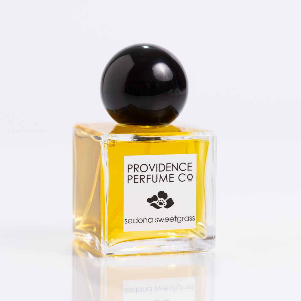 Perfume bottle with black cap and 'Providence Perfume Co' label on a white background