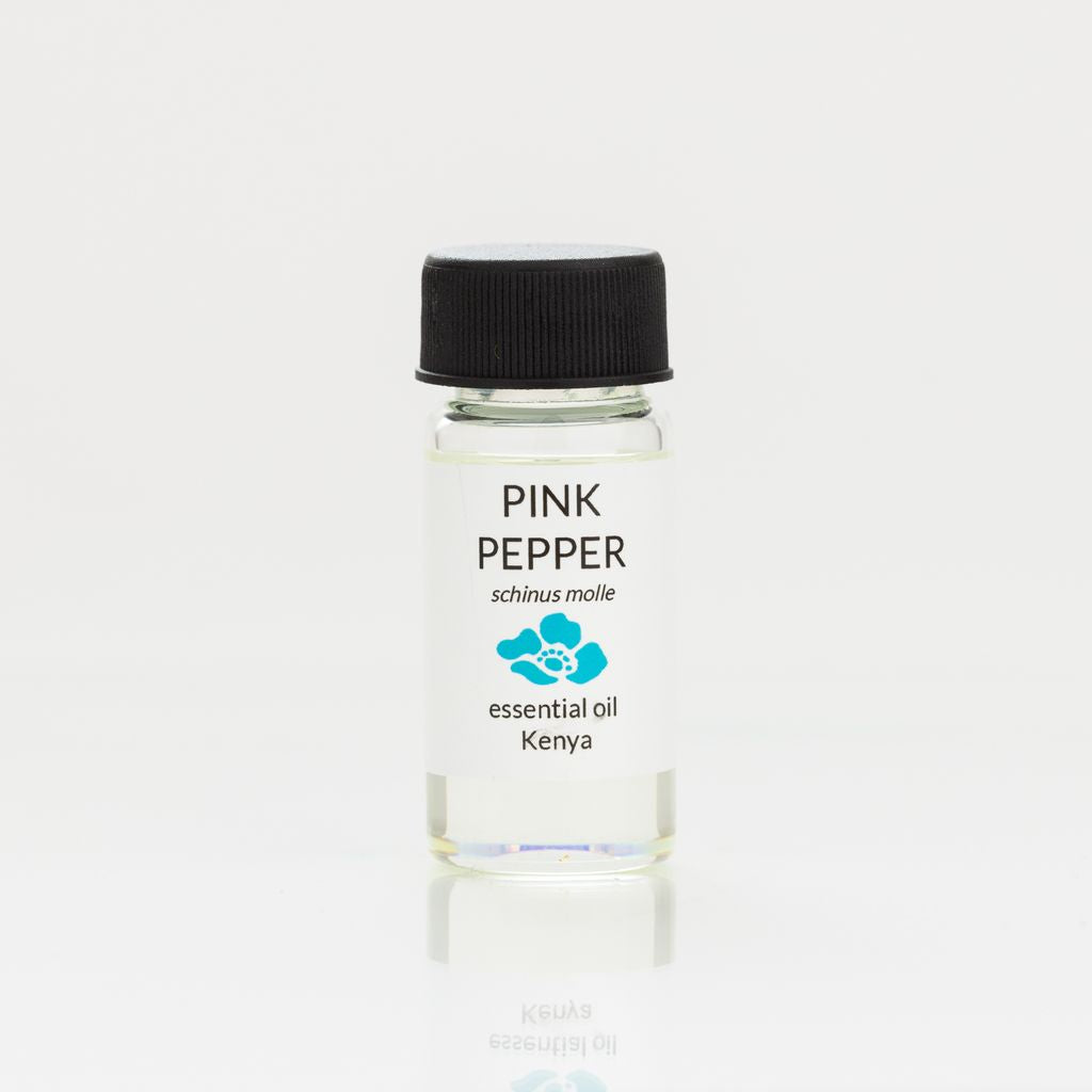 Bottle of pink pepper essential oil with a black cap on a white background