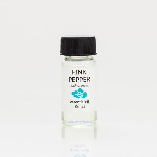 Bottle of pink pepper essential oil with a black cap on a white background